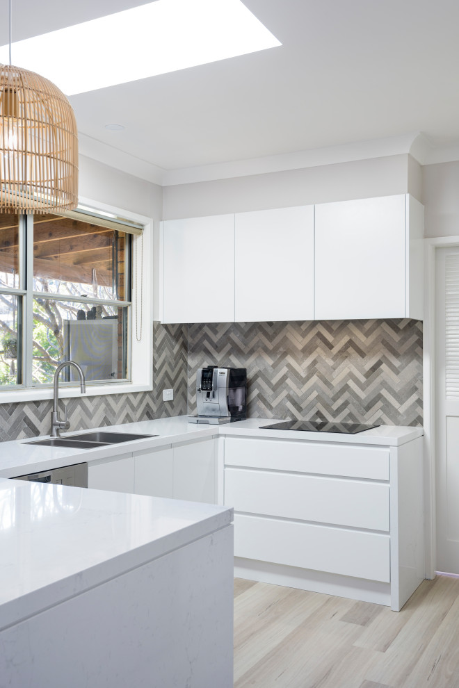Photo of a small u-shaped separate kitchen in Newcastle - Maitland with flat-panel cabinets, white cabinets, quartz benchtops, ceramic splashback, with island and white benchtop.
