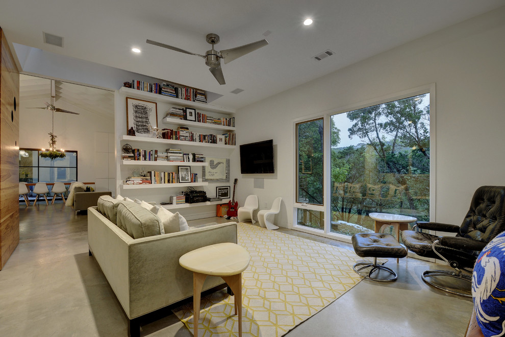 This is an example of a large eclectic open concept living room in Austin with a music area, white walls, concrete floors, no fireplace and grey floor.