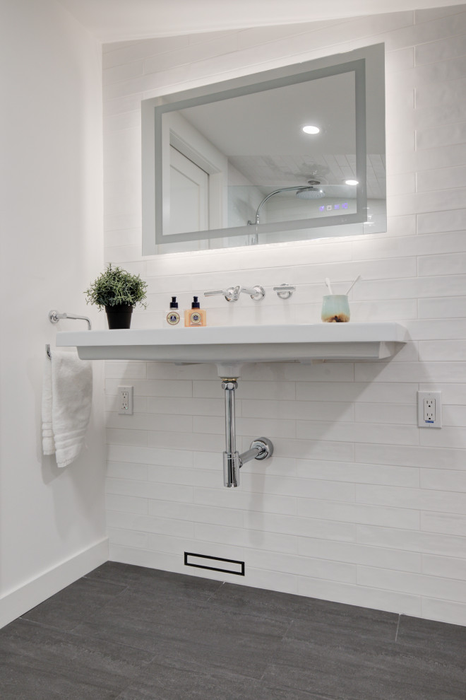 Inspiration for a small midcentury ensuite bathroom in Other with a built-in shower, a wall mounted toilet, white tiles, ceramic tiles, white walls, wood-effect flooring, a wall-mounted sink, grey floors, an open shower, a wall niche and a single sink.