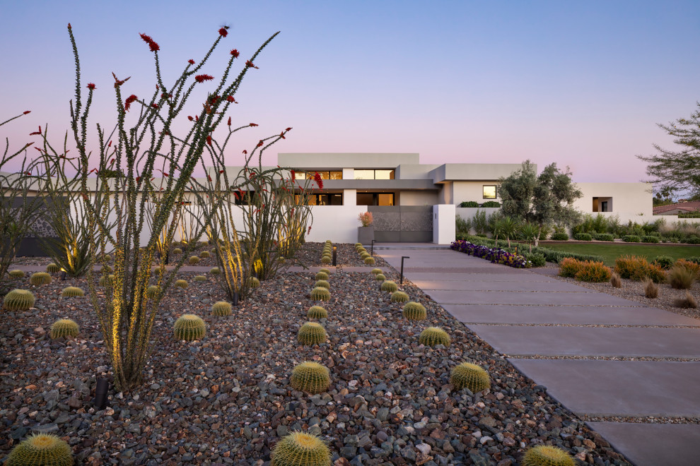 Photo of an expansive modern one-storey white house exterior in Phoenix with stone veneer, a flat roof and a white roof.