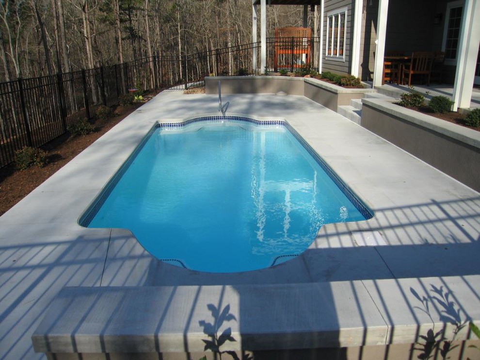 Pool - backyard concrete and custom-shaped pool idea
