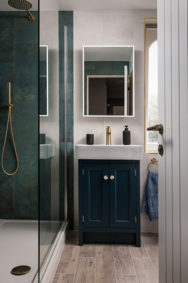 На фото: ванная комната среднего размера в стиле неоклассика (современная классика) с фасадами в стиле шейкер, синими фасадами, открытым душем, зеленой плиткой, керамогранитной плиткой, белыми стенами, полом из плитки под дерево, душевой кабиной, раковиной с пьедесталом, бежевым полом, открытым душем, акцентной стеной, тумбой под одну раковину и напольной тумбой