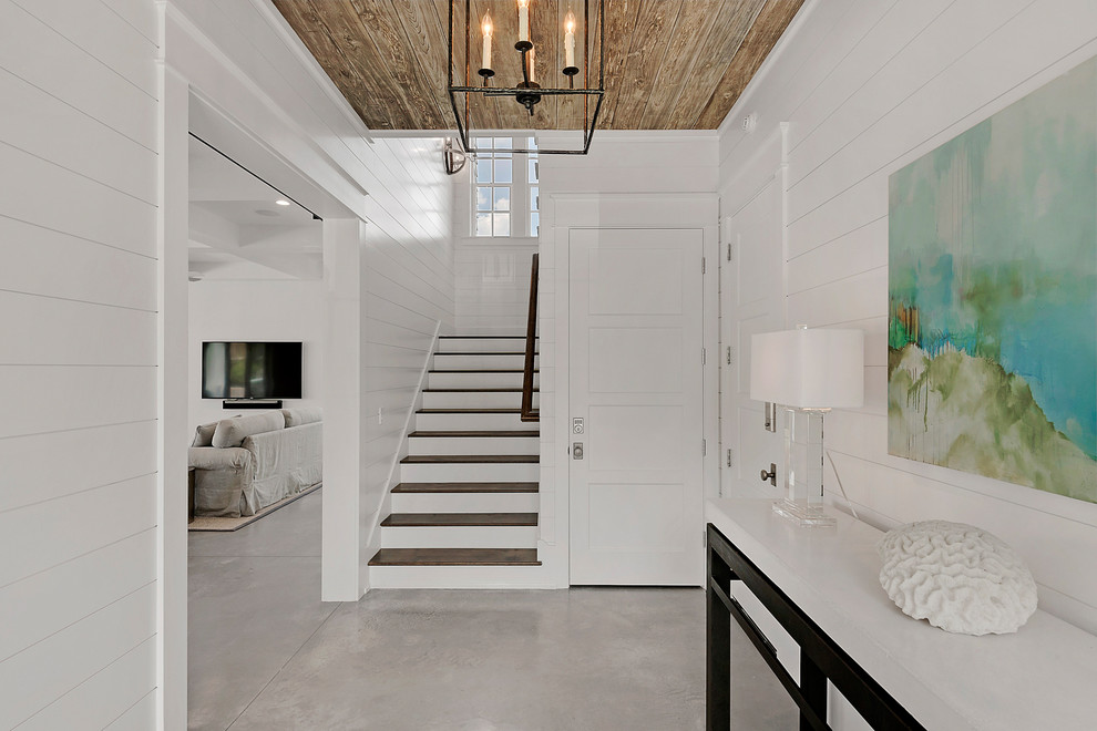 Inspiration for a mid-sized beach style foyer in Miami with white walls, concrete floors and grey floor.