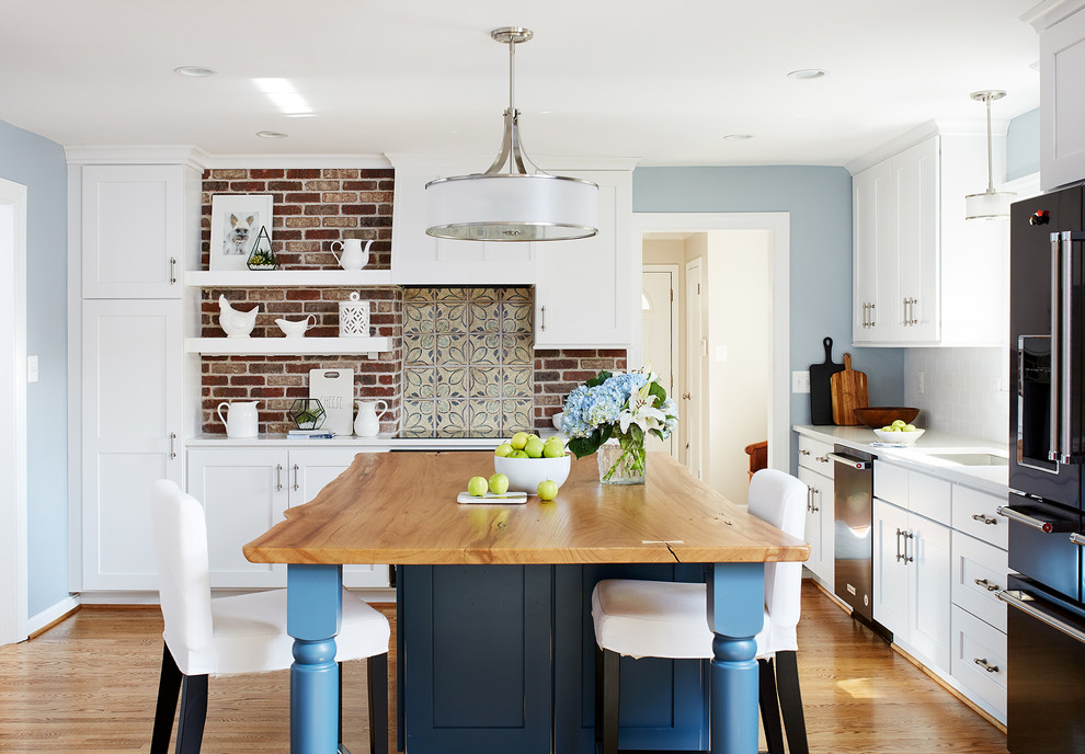 Inspiration for a mid-sized transitional l-shaped eat-in kitchen in DC Metro with white cabinets, brick splashback, medium hardwood floors and with island.