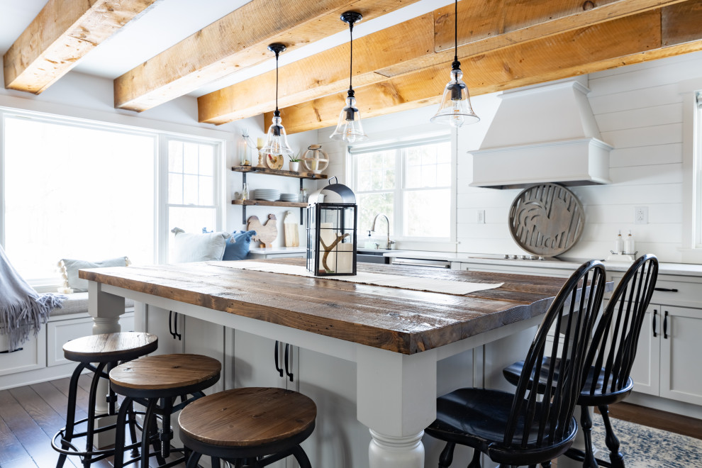 Imagen de cocina de estilo de casa de campo, grande, con fregadero sobremueble, armarios estilo shaker, puertas de armario grises, encimera de mármol, salpicadero blanco, puertas de machihembrado, electrodomésticos de acero inoxidable, suelo de madera oscura, una isla, suelo marrón, encimeras blancas y vigas vistas