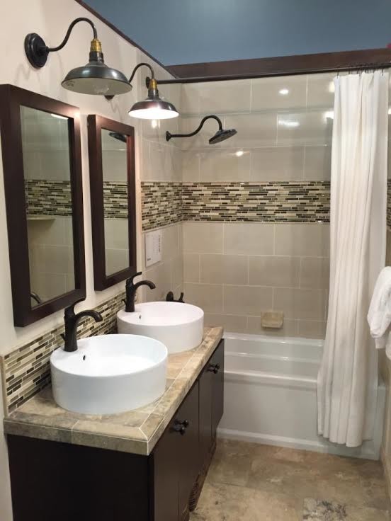 This is an example of a small contemporary 3/4 bathroom in Baltimore with flat-panel cabinets, black cabinets, an alcove tub, a shower/bathtub combo, multi-coloured tile, glass tile, beige walls, limestone floors, a vessel sink and tile benchtops.