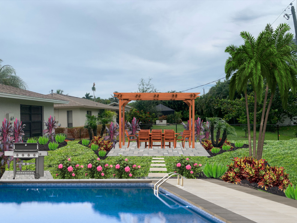 Large tropical backyard full sun formal garden in Miami with a garden path and brick pavers.