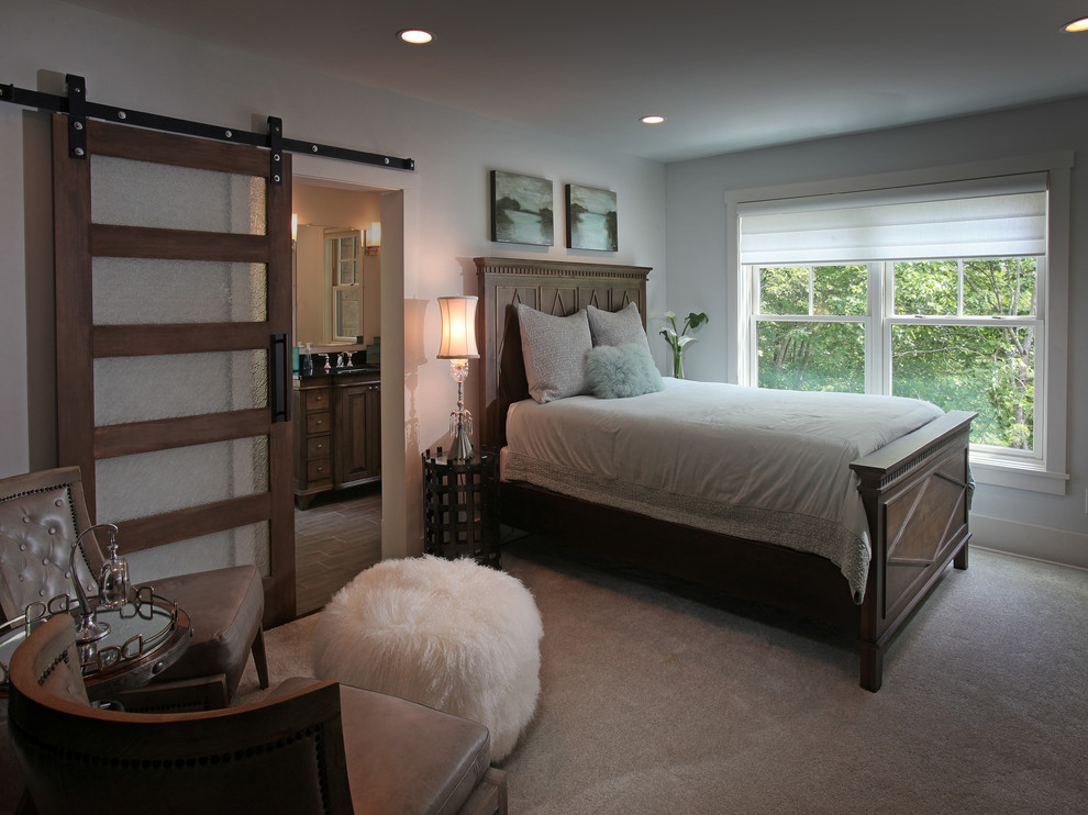 This is an example of a mid-sized country master bedroom in Atlanta with beige walls and carpet.