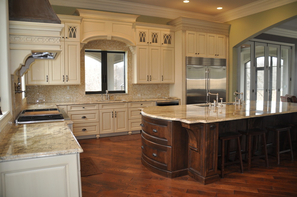 Photo of a large traditional l-shaped open plan kitchen in Baltimore with an undermount sink, raised-panel cabinets, white cabinets, granite benchtops, beige splashback, stainless steel appliances, dark hardwood floors, with island and brown floor.