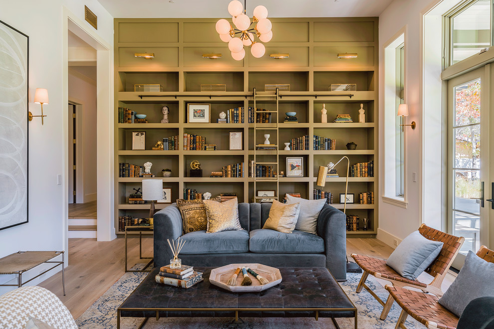 Design ideas for an expansive contemporary enclosed family room in Los Angeles with a library, white walls, light hardwood floors, no tv and beige floor.