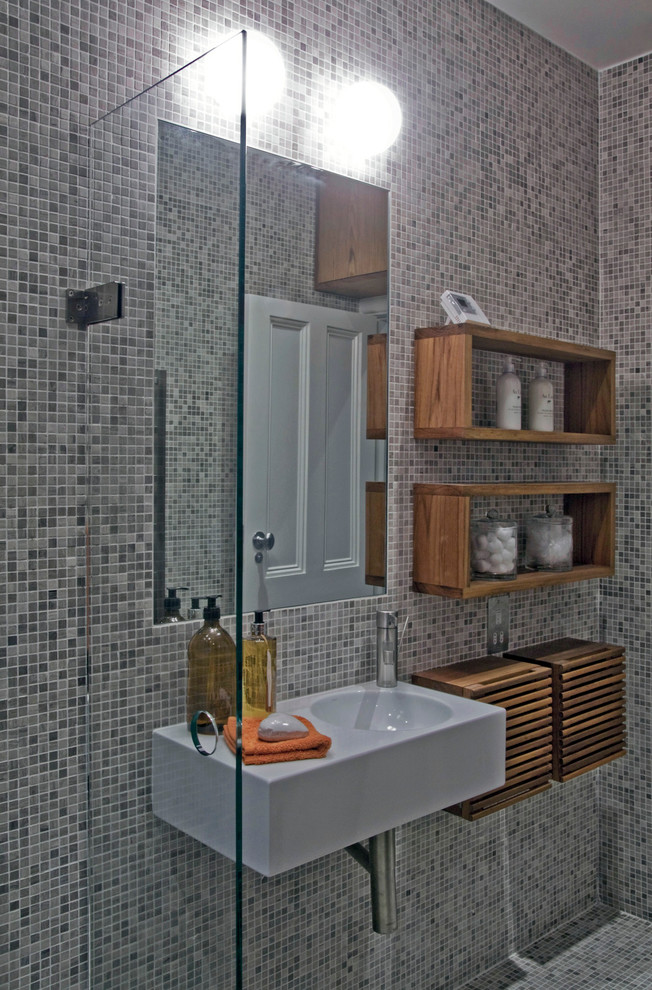 This is an example of a small modern 3/4 bathroom in London with a vessel sink, open cabinets, dark wood cabinets, wood benchtops, an open shower, a wall-mount toilet, gray tile, mosaic tile, grey walls and mosaic tile floors.