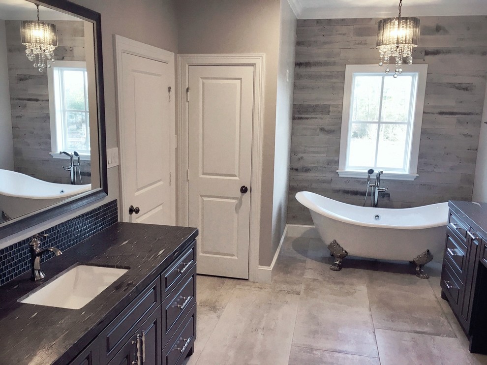 This is an example of a mid-sized transitional master wet room bathroom in Houston with raised-panel cabinets, dark wood cabinets, a claw-foot tub, a one-piece toilet, gray tile, ceramic tile, grey walls, ceramic floors, an undermount sink and granite benchtops.