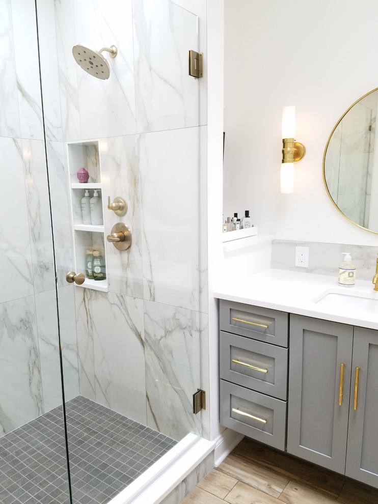 This is an example of a mid-sized contemporary master bathroom in Other with shaker cabinets, grey cabinets, an alcove shower, a one-piece toilet, gray tile, ceramic tile, white walls, ceramic floors, an undermount sink, granite benchtops, beige floor and a hinged shower door.