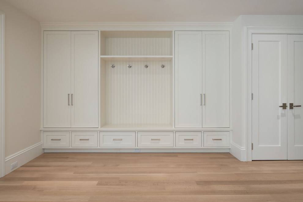 Large contemporary mudroom in Boston with white walls, light hardwood floors, beige floor and wood walls.