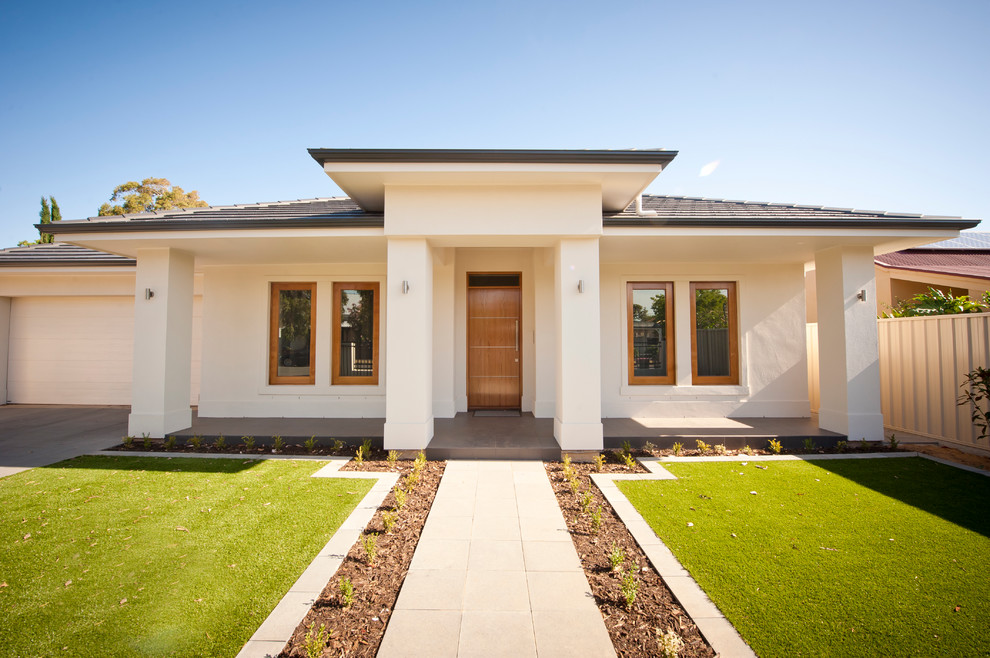 This is an example of a mid-sized contemporary one-storey concrete beige house exterior in Adelaide with a hip roof and a tile roof.