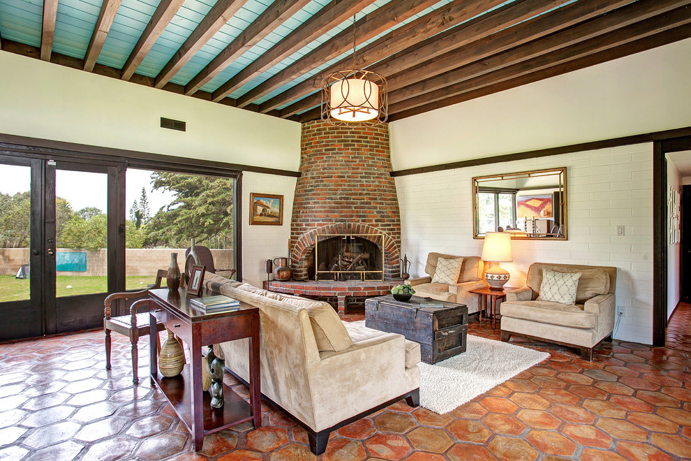 Inspiration for a midcentury living room in San Diego with terra-cotta floors, a corner fireplace and a brick fireplace surround.
