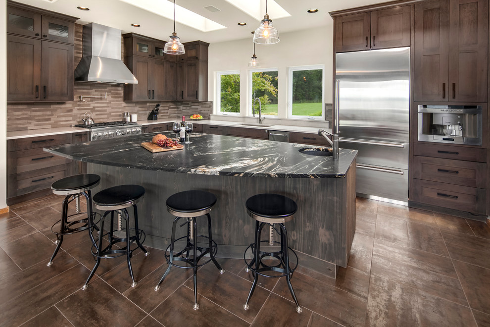 This is an example of a mid-sized transitional l-shaped separate kitchen in Phoenix with an undermount sink, shaker cabinets, dark wood cabinets, quartz benchtops, beige splashback, stone tile splashback, stainless steel appliances, porcelain floors, with island and brown floor.