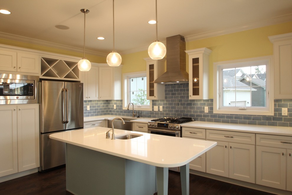 Inspiration for a large transitional u-shaped dark wood floor enclosed kitchen remodel in Cedar Rapids with a farmhouse sink, recessed-panel cabinets, white cabinets, quartzite countertops, blue backsplash, ceramic backsplash, stainless steel appliances and yellow walls