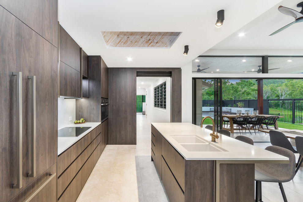 Design ideas for a large contemporary galley eat-in kitchen in Townsville with a double-bowl sink, dark wood cabinets, white splashback, ceramic floors, with island, beige floor, white benchtop, flat-panel cabinets and coloured appliances.