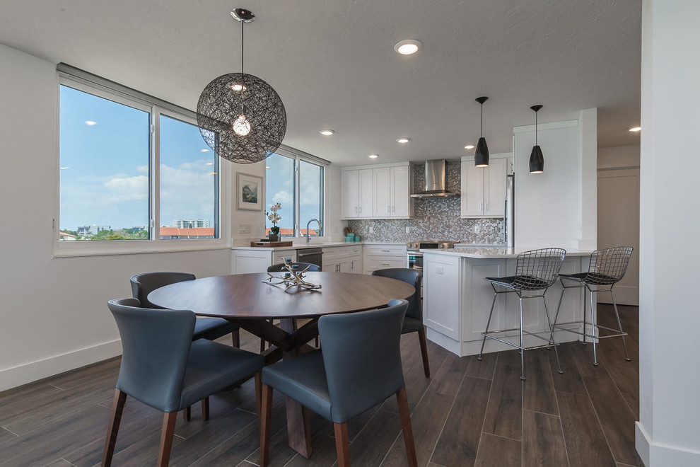 Inspiration for a beach style kitchen/dining combo in Tampa with white walls and dark hardwood floors.