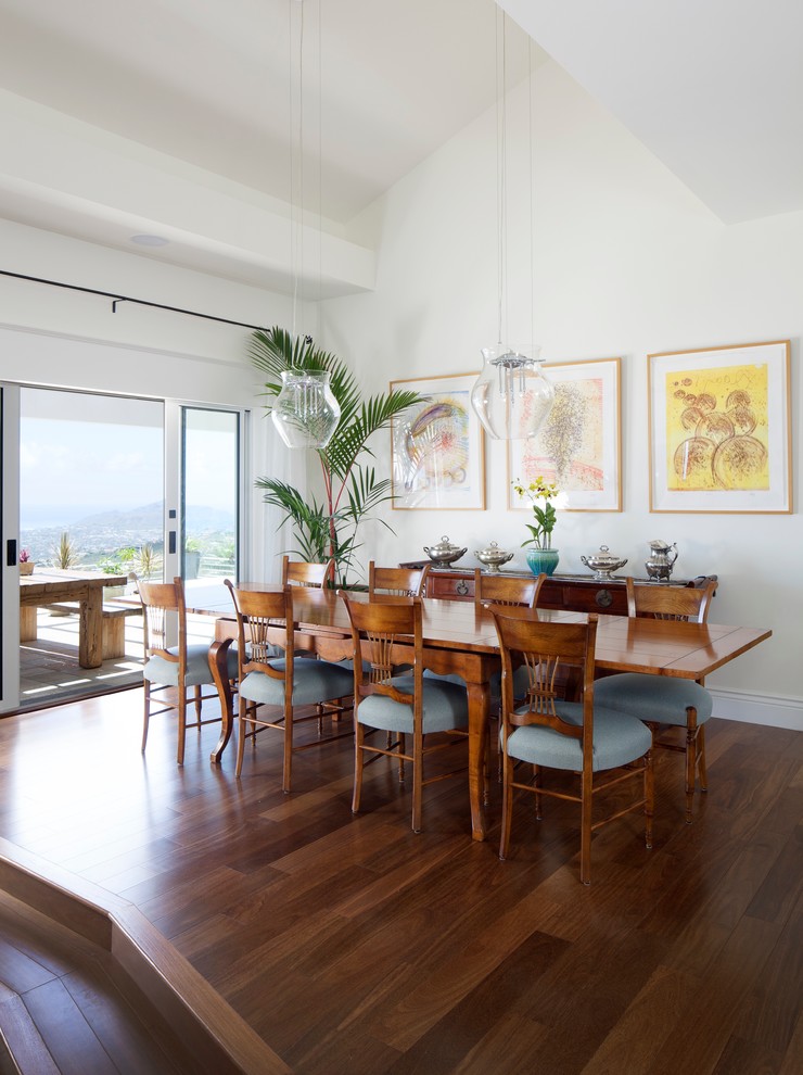 Tropical dining room in Hawaii with white walls and dark hardwood floors.
