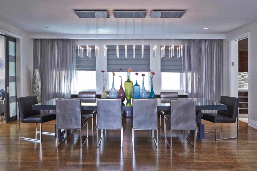 Photo of a large modern open plan dining in New York with medium hardwood floors and grey walls.