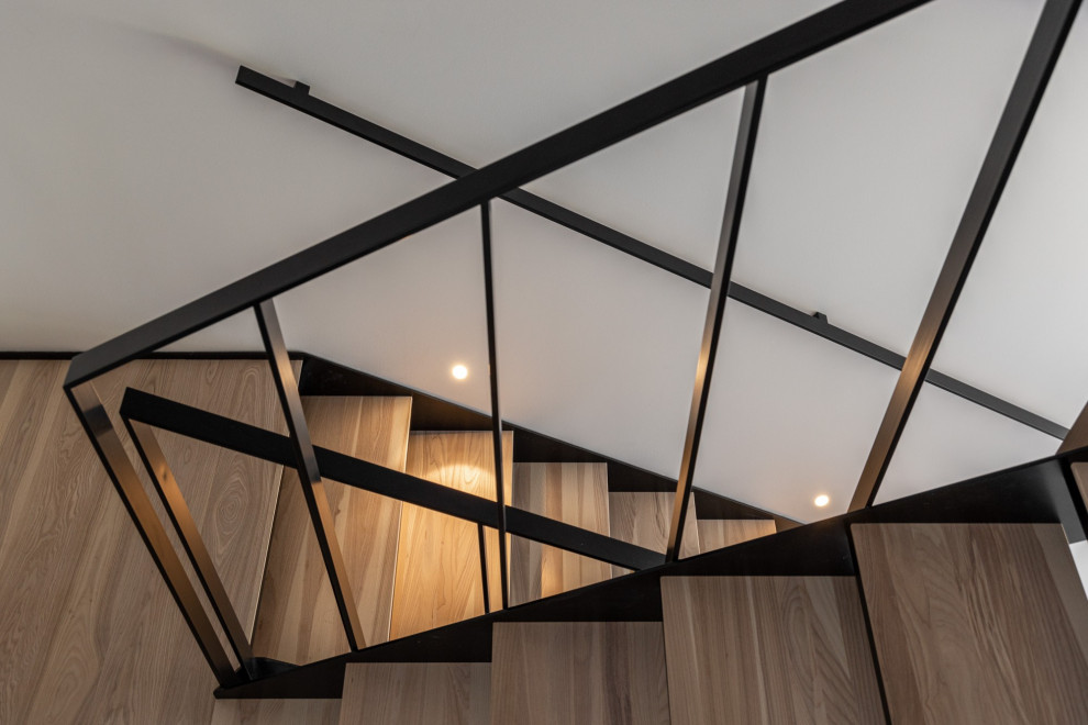 Foto de escalera recta actual de tamaño medio con escalones de madera, contrahuellas de metal y barandilla de metal