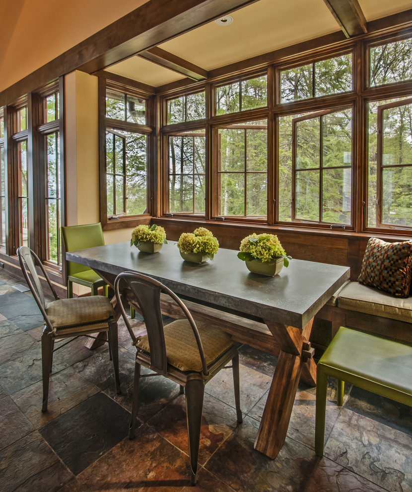 Country dining room in Milwaukee with beige walls and slate floors.