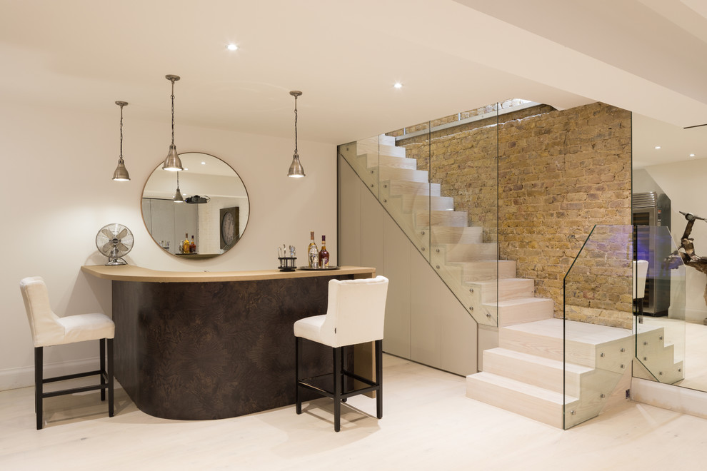This is an example of a mid-sized contemporary kitchen in London with light hardwood floors.