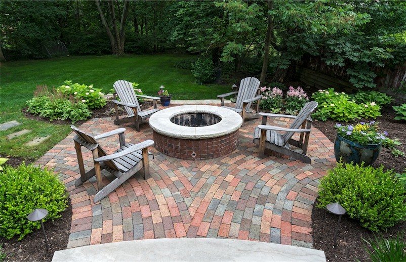Inspiration for a mid-sized traditional backyard patio in Cleveland with a fire feature, brick pavers and no cover.