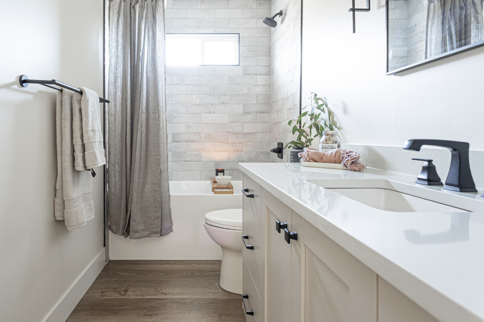 Exempel på ett mellanstort modernt flerfärgad flerfärgat badrum med dusch, med skåp i shakerstil, grå skåp, ett badkar i en alkov, en toalettstol med hel cisternkåpa, grå kakel, keramikplattor, vita väggar, vinylgolv, ett undermonterad handfat, bänkskiva i kvartsit och brunt golv