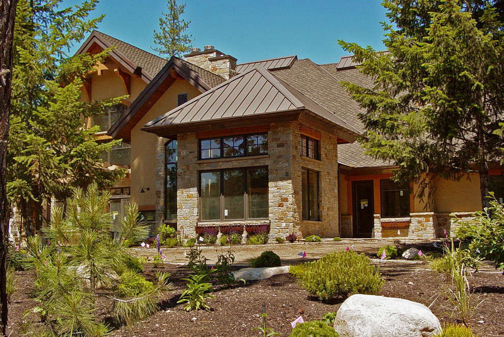 Design ideas for an arts and crafts split-level beige exterior in Seattle with stone veneer.
