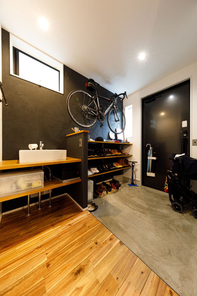 This is an example of an industrial entryway in Tokyo with black walls and a black front door.