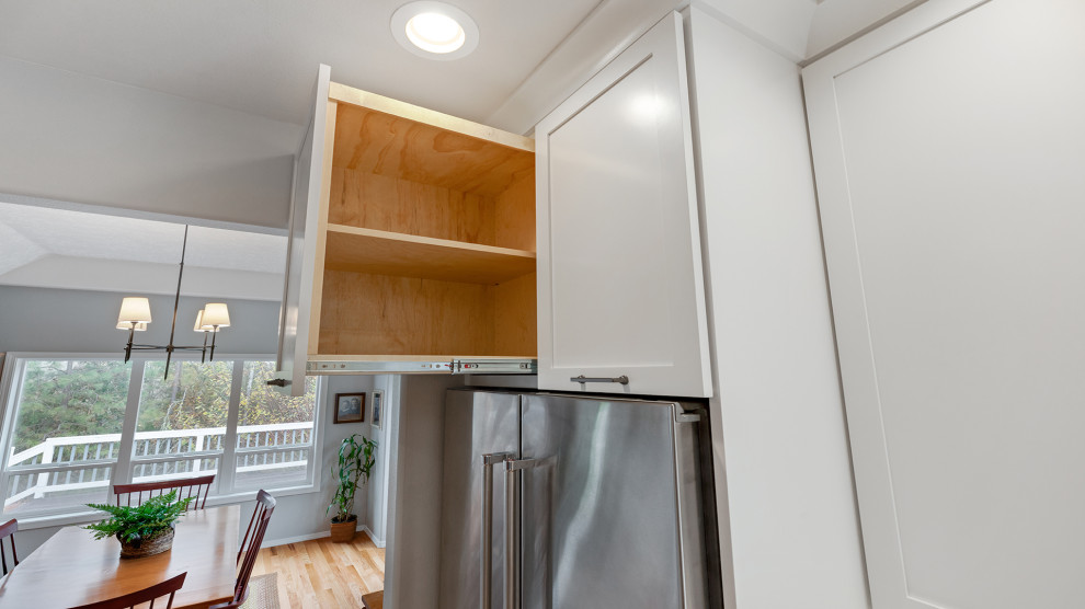 Large galley eat-in kitchen in Portland with an undermount sink, shaker cabinets, dark wood cabinets, multi-coloured splashback, cement tile splashback, stainless steel appliances, medium hardwood floors, with island, brown floor and white benchtop.