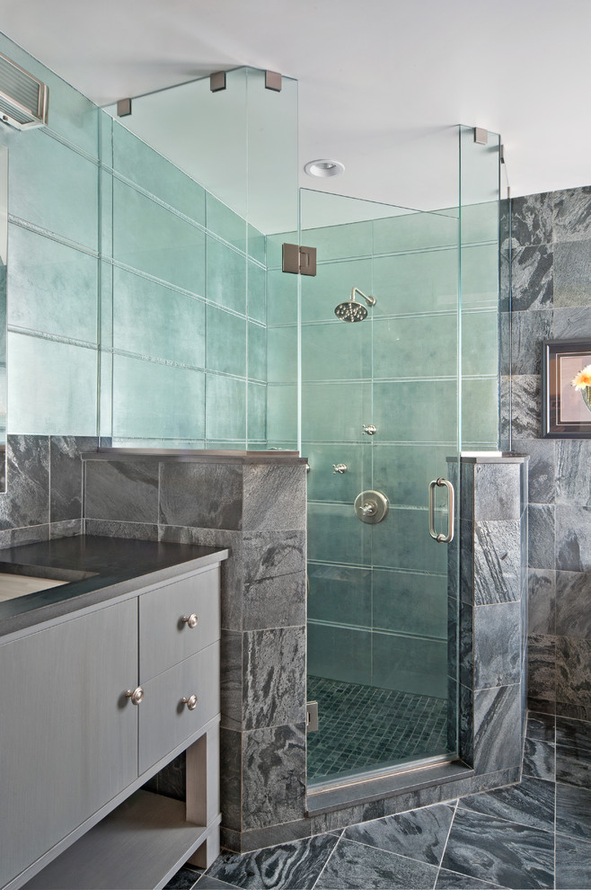 Photo of a large contemporary master bathroom in New York with an undermount sink, flat-panel cabinets, grey cabinets, granite benchtops, a corner shower, gray tile, glass tile, grey walls and marble floors.