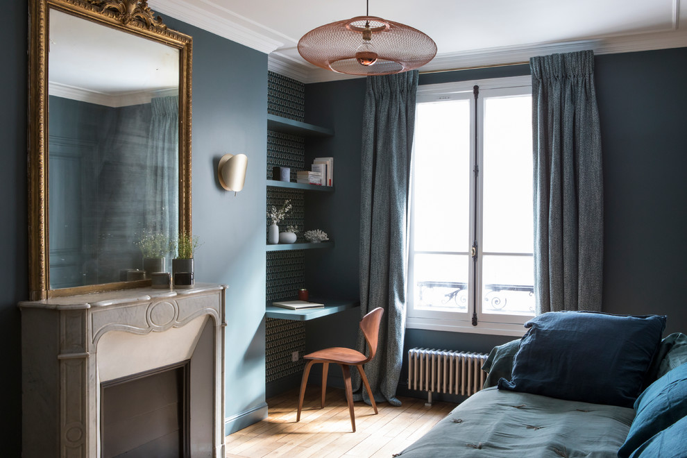 Design ideas for a small contemporary master bedroom in Paris with blue walls, light hardwood floors, a corner fireplace, a stone fireplace surround and beige floor.