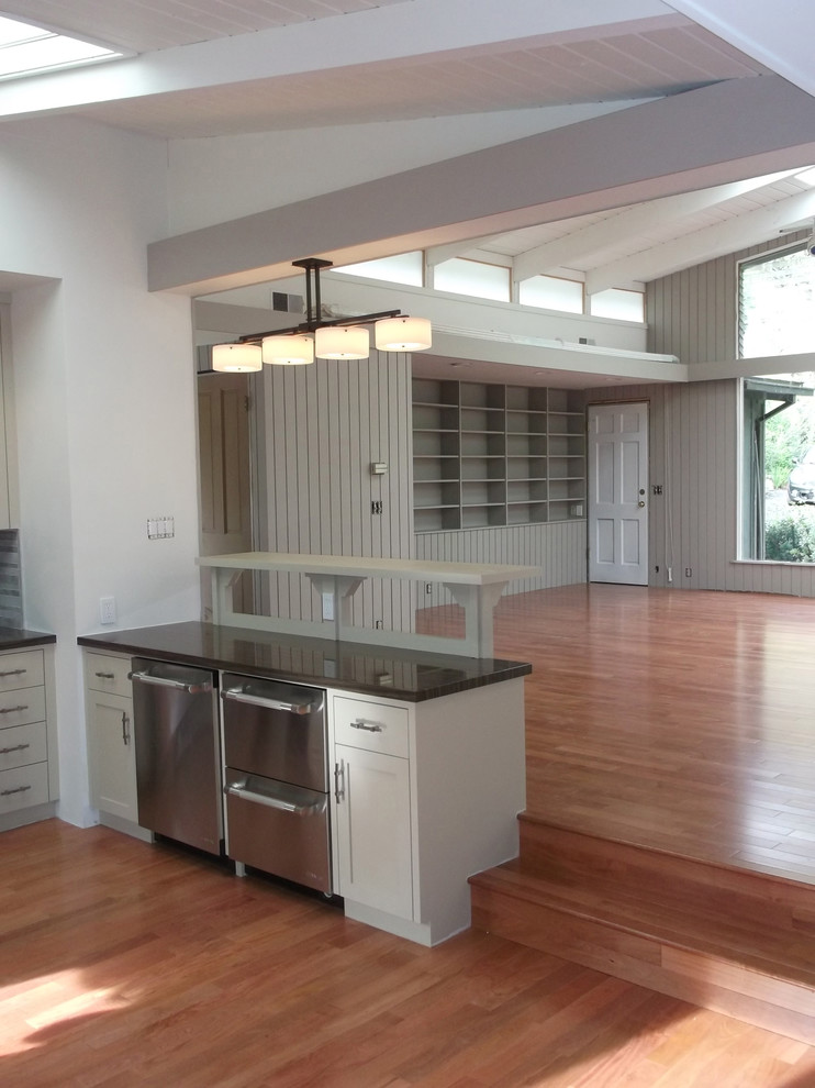 Mid-sized contemporary l-shaped eat-in kitchen in Other with an undermount sink, shaker cabinets, grey cabinets, limestone benchtops, grey splashback, stone tile splashback, stainless steel appliances, medium hardwood floors and no island.
