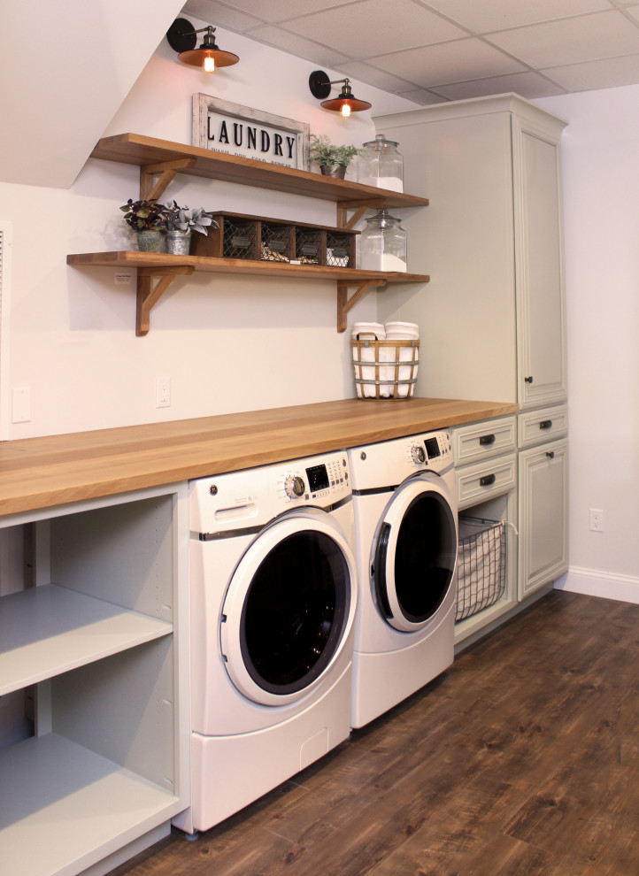 Photo of a single-wall utility room in Other with wood benchtops, a side-by-side washer and dryer and brown benchtop.