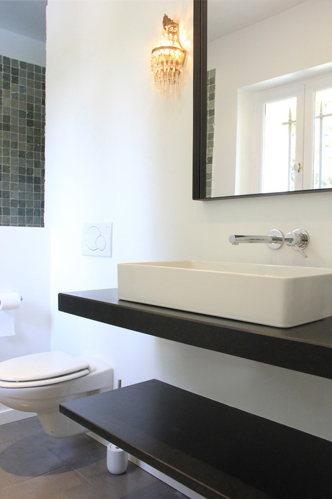 Mid-sized mediterranean master bathroom in Paris with flat-panel cabinets, black cabinets, a curbless shower, a wall-mount toilet, black and white tile, ceramic tile, white walls, marble floors, engineered quartz benchtops, black floor, a hinged shower door and a drop-in sink.