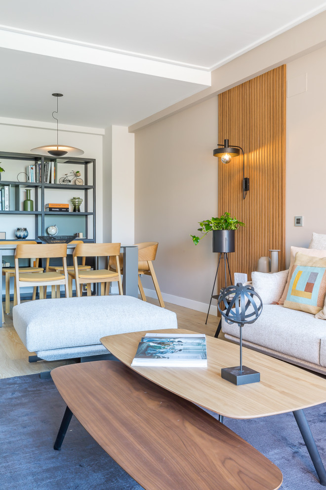 На фото: изолированная, серо-белая гостиная комната среднего размера в современном стиле с серыми стенами, светлым паркетным полом, отдельно стоящим телевизором, коричневым полом и деревянными стенами