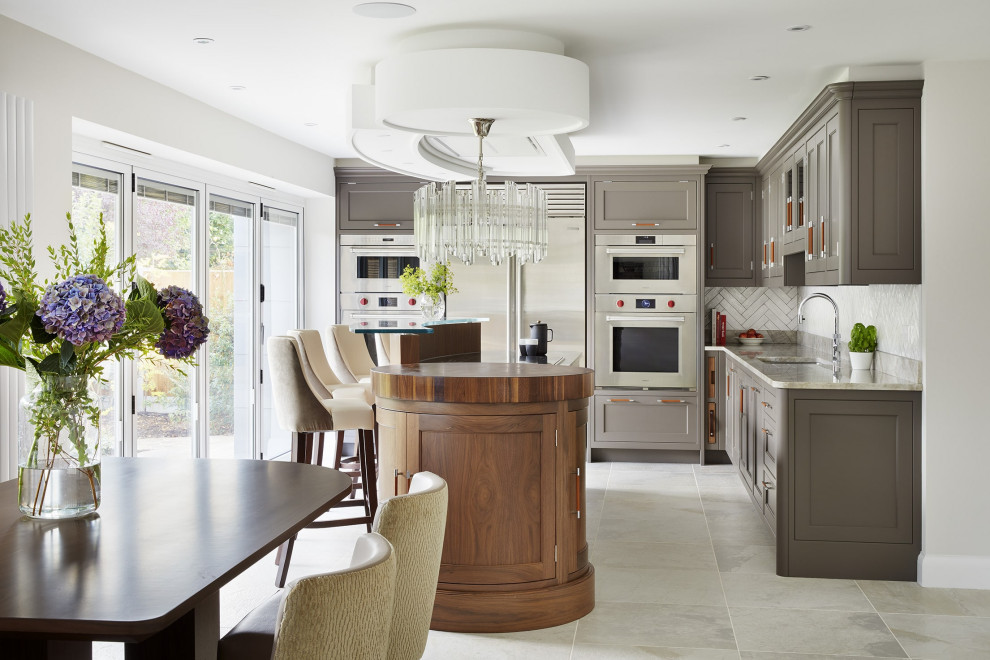 Inspiration for a contemporary porcelain tile and gray floor eat-in kitchen remodel in Essex with an integrated sink, beaded inset cabinets, gray cabinets, granite countertops, white backsplash, porcelain backsplash, stainless steel appliances, an island and beige countertops