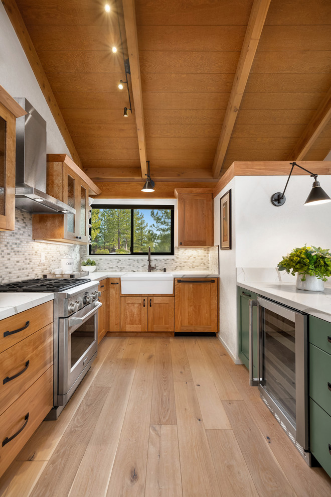 Exempel på ett mellanstort rustikt flerfärgad flerfärgat kök, med en rustik diskho, skåp i shakerstil, gröna skåp, bänkskiva i kvarts, grönt stänkskydd, stänkskydd i porslinskakel, integrerade vitvaror, ljust trägolv, en halv köksö och beiget golv