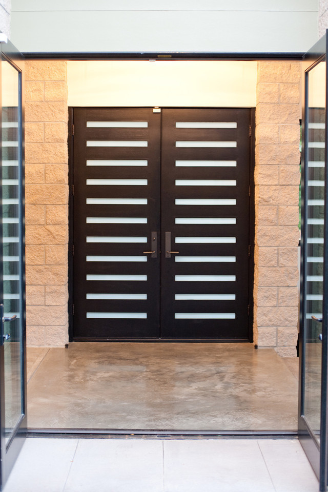 This is an example of a mid-sized modern front door in Denver with white walls, concrete floors, a double front door, a black front door and grey floor.
