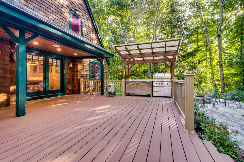 Photo of a mid-sized arts and crafts backyard deck in Boston with an outdoor kitchen and a roof extension.