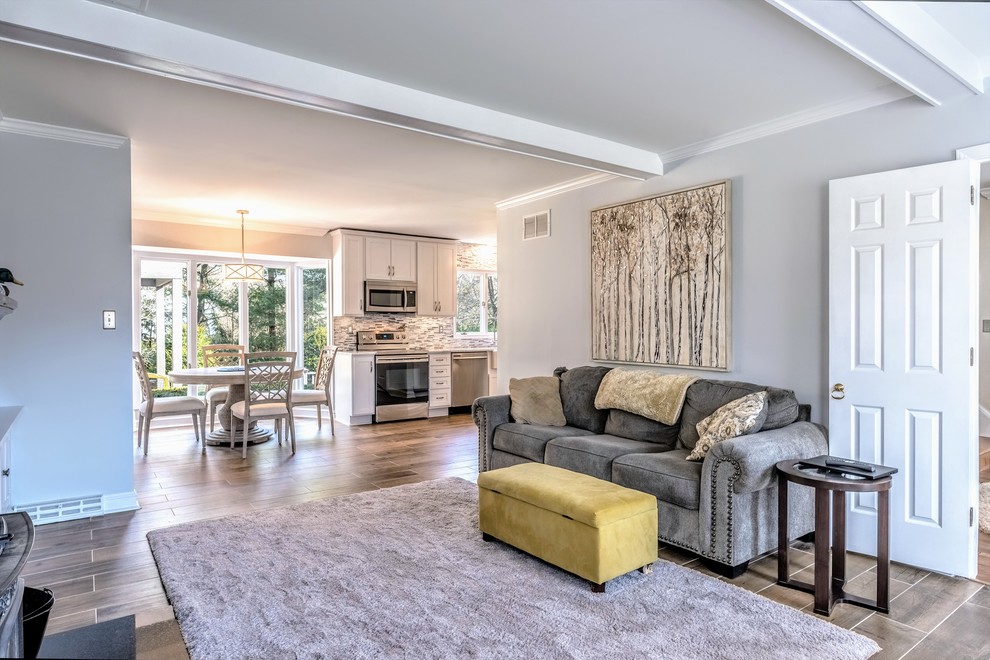 Example of a large transitional l-shaped ceramic tile and brown floor eat-in kitchen design in Baltimore with a farmhouse sink, shaker cabinets, white cabinets, granite countertops, gray backsplash, stone tile backsplash, stainless steel appliances, no island and white countertops
