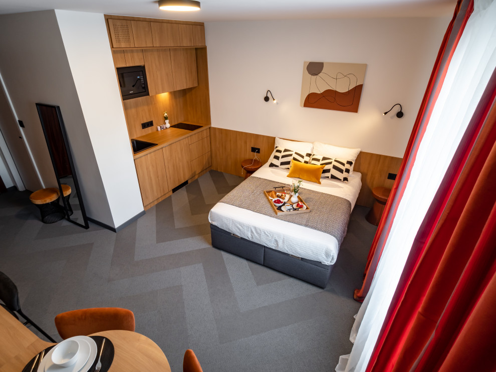 Esempio di una piccola camera da letto minimal con pareti bianche, moquette e pavimento grigio