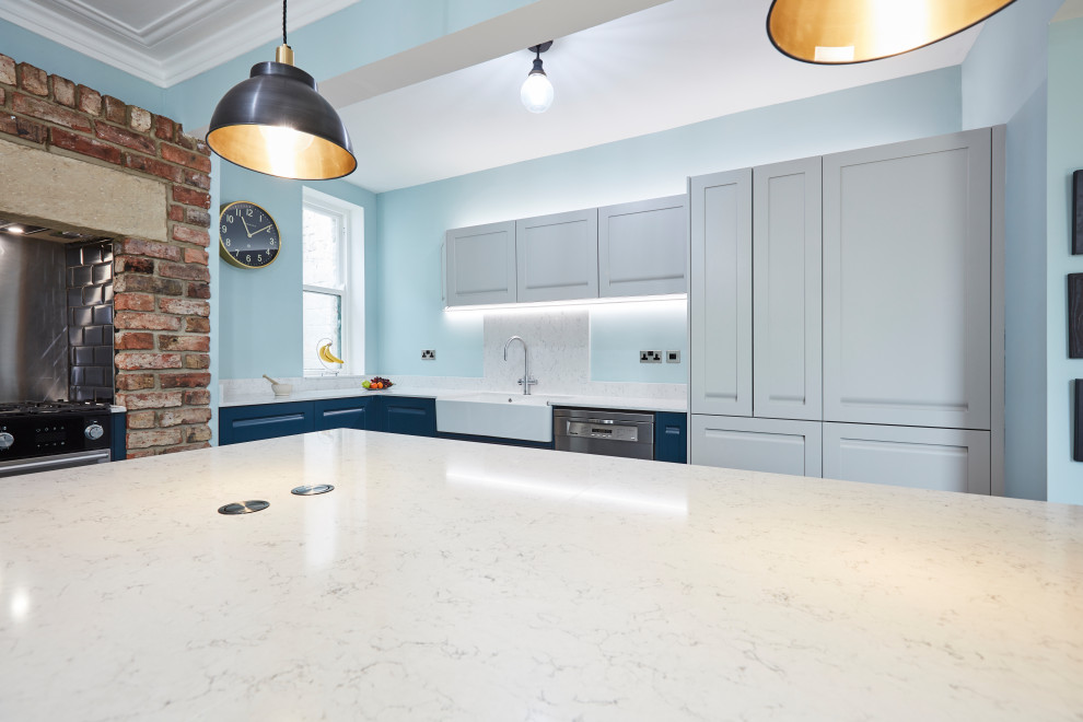 This is an example of a mid-sized l-shaped eat-in kitchen in Other with a farmhouse sink, shaker cabinets, blue cabinets, marble benchtops, white splashback, marble splashback, stainless steel appliances, porcelain floors, multiple islands, blue floor, white benchtop and coffered.