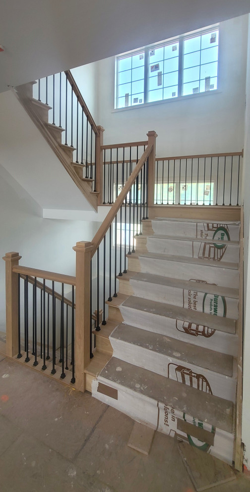 Cette photo montre un grand escalier tendance en L avec des marches en bois, des contremarches en bois et un garde-corps en matériaux mixtes.