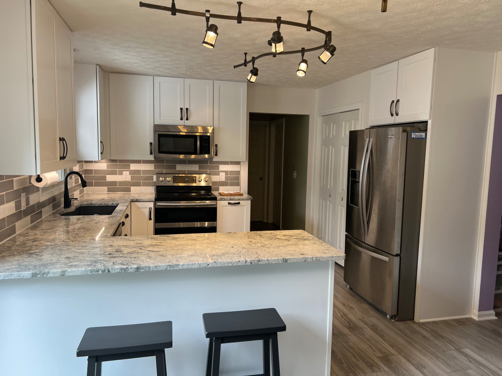 Mid-sized elegant u-shaped eat-in kitchen photo in Cleveland with shaker cabinets, white cabinets, granite countertops and ceramic backsplash