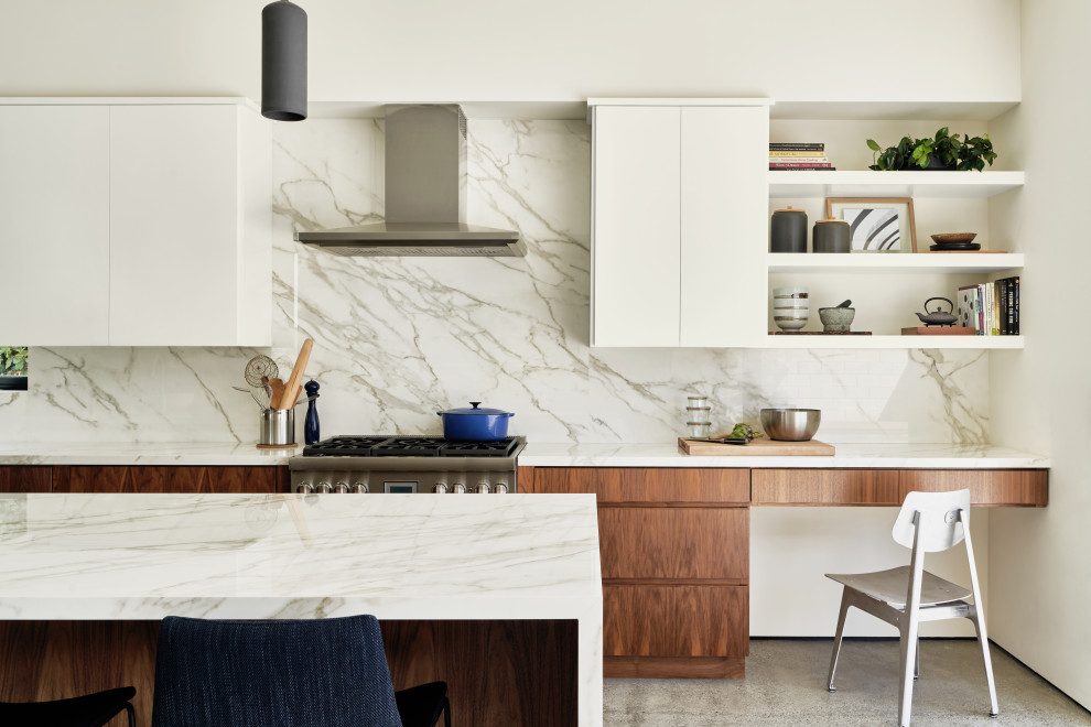This is an example of a mid-sized contemporary l-shaped open plan kitchen in Los Angeles with a farmhouse sink, flat-panel cabinets, dark wood cabinets, quartz benchtops, white splashback, engineered quartz splashback, panelled appliances, concrete floors, with island, grey floor and white benchtop.